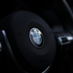 Detailed view of a BMW steering wheel emblem with a stylish depth of field effect.